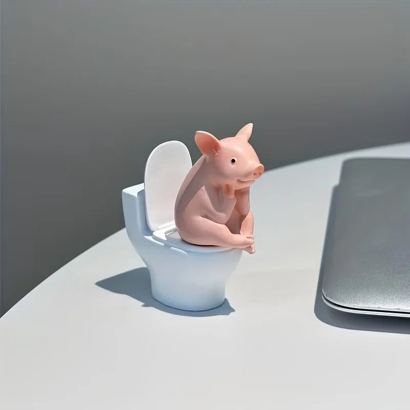 A Little Pig Figurine Sitting on the Toilet - A Decorative Item, Placed on the Table or Wall, on a Home Office Desk
