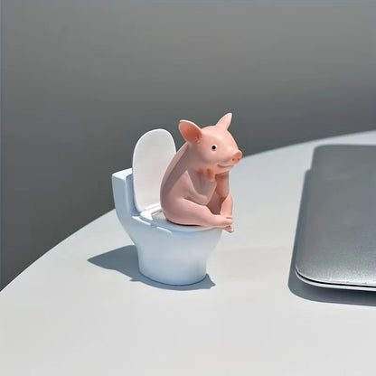 A Little Pig Figurine Sitting on the Toilet - A Decorative Item, Placed on the Table or Wall, on a Home Office Desk