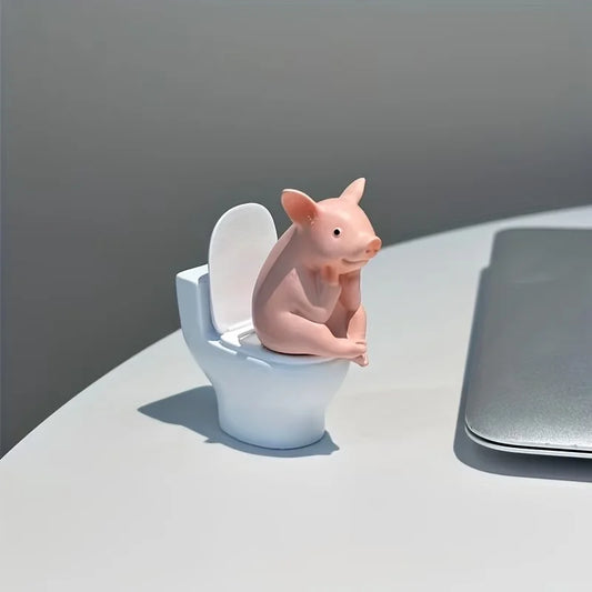 A Little Pig Figurine Sitting on the Toilet - A Decorative Item, Placed on the Table or Wall, on a Home Office Desk