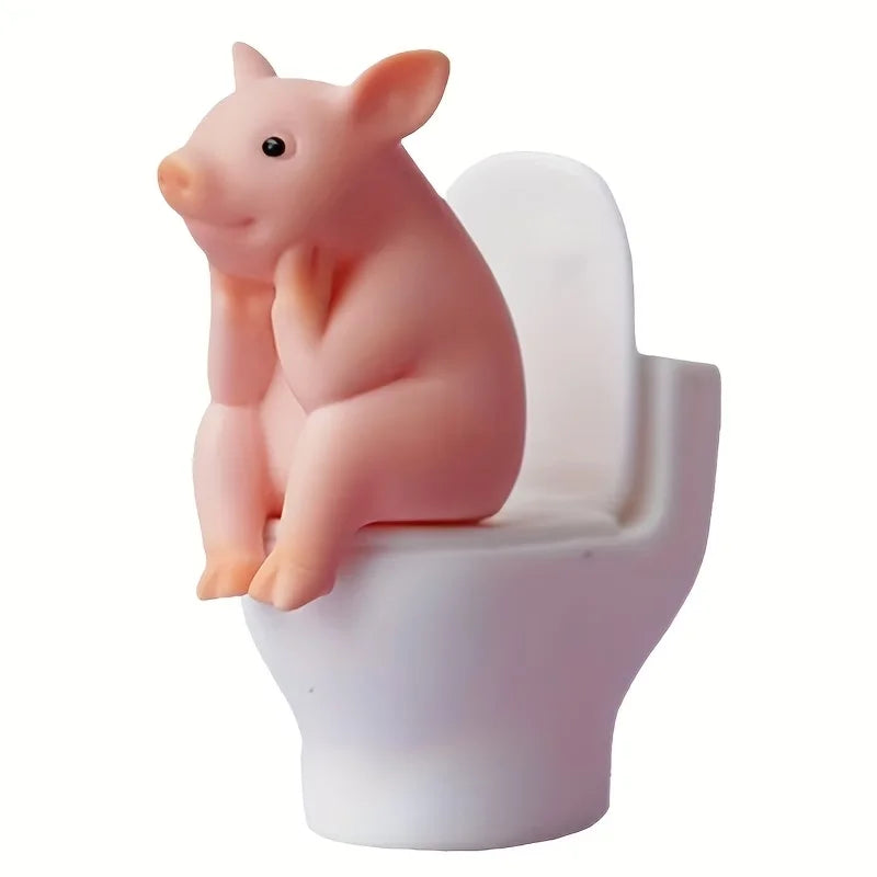 A Little Pig Figurine Sitting on the Toilet - A Decorative Item, Placed on the Table or Wall, on a Home Office Desk