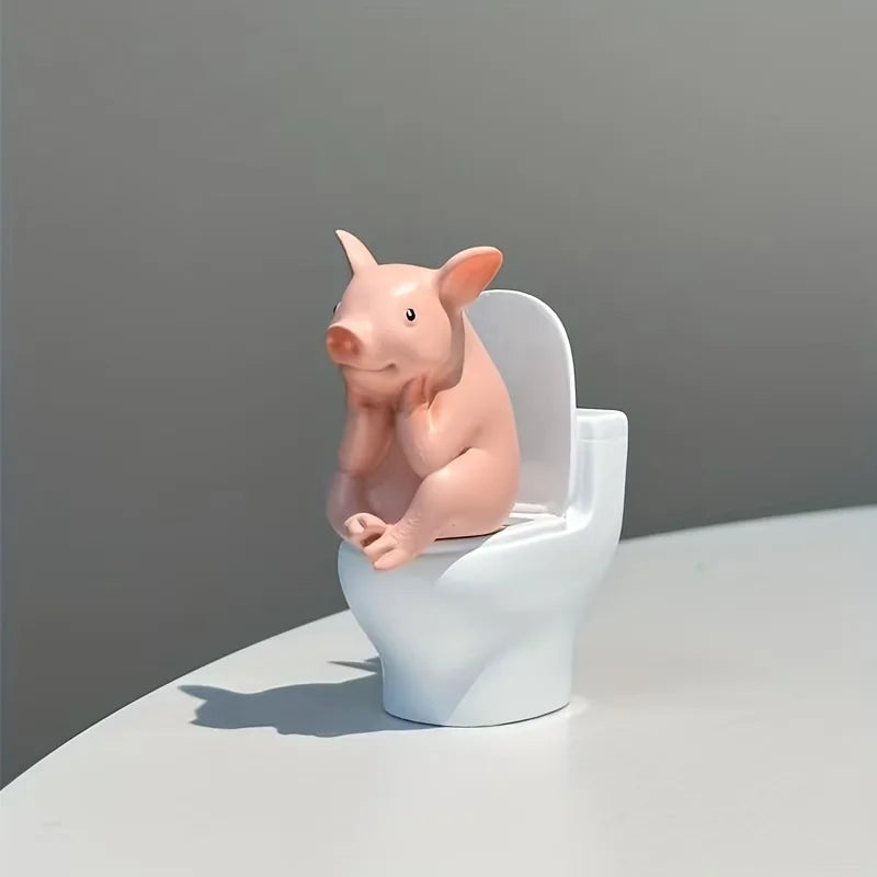 A Little Pig Figurine Sitting on the Toilet - A Decorative Item, Placed on the Table or Wall, on a Home Office Desk