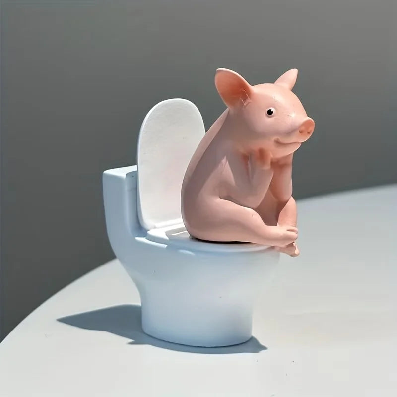 A Little Pig Figurine Sitting on the Toilet - A Decorative Item, Placed on the Table or Wall, on a Home Office Desk