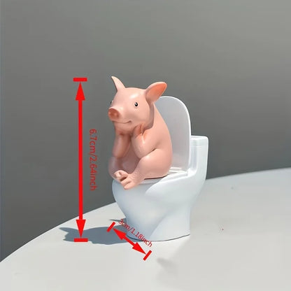 A Little Pig Figurine Sitting on the Toilet - A Decorative Item, Placed on the Table or Wall, on a Home Office Desk